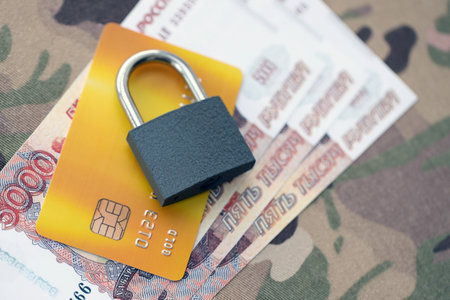 Russian rubles money bills and credit card under ban of heavy lockpad close up. Concept of sanctions and restrictions to russian citizensの写真素材