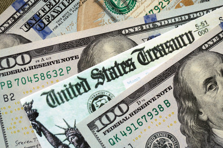 United States Treasury refund check or stimulus bill with many hundred dollars banknotes close up