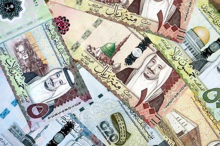 Saudi Arabia riyal money bills banknotes lies in big pile on table close up. Concept of finances and...