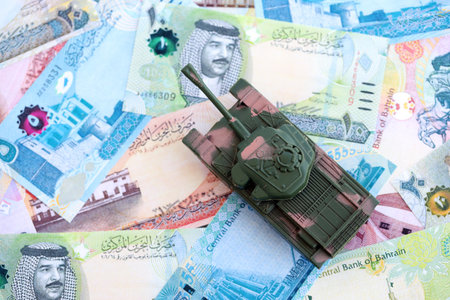Bahraini dinar currency money bills and toy tank close up. The concept of army funds and weapons...