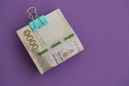 Thai baht money bills in big amount on purple close up. Finance and banking concept
