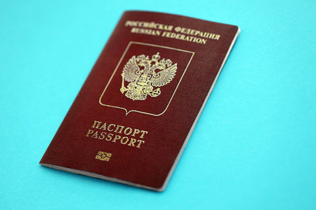Russian Federation red passport on light blue table background close up. Concept of travel and tourismの写真素材