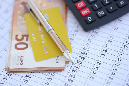 Credit card and pen with euro currency money bills banknotes on calculations document background. Business, financial operations and accounting in European Unionの写真素材