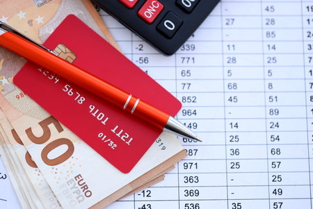 Credit card and pen with euro currency money bills banknotes on calculations document background. Business, financial operations and accounting in European Unionの写真素材