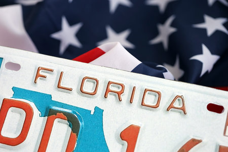 USA state of Florida license plate on US flag. Concept of driving in Florida. Reaching a driving permitの写真素材