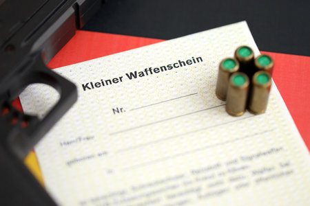 German light firearms license and handgun with bullets on Germany flag close up. Gun permit for light weapon carrying in Deutschlandの写真素材