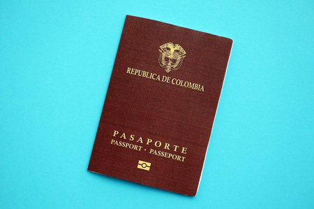Colombia red passport on light blue table background close up. Concept of travel and tourismの写真素材