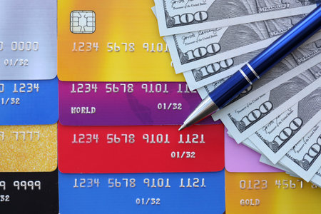 Credit cards and pen with US dollar currency money bills banknotes. Business, financial operations and accounting in United States of Americaの写真素材