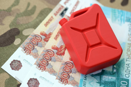 Petrol canister on russian roubles money bills on camouflage fabric. Concept of petroleum export from Russiaの写真素材