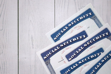 Social security number cards on white wooden background surface close up