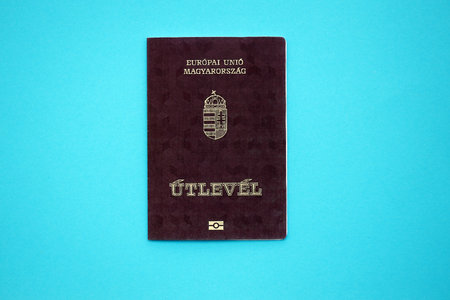 Hungarian passport book on light blue paper background close up. Travel document on blue surface