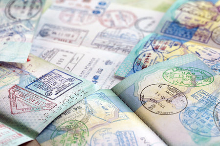 Many open passport pages with lots of visas and entrance stamps from various countries passport...