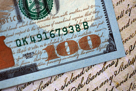 One hundred US dollar bills and United States Constitution page fragment. Concept of lawsuit in United Statesの写真素材