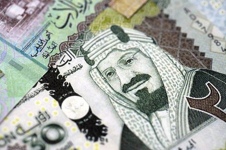 Saudi Arabia riyal money bills banknotes lies in big pile on table close up. Concept of finances and...