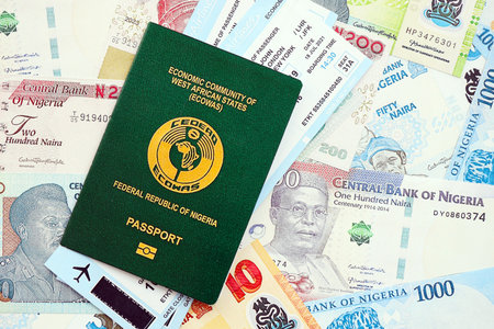 Nigerian naira currency money bills with tickets and passport close up. The concept of travel and...