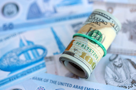 United Arab Emirates dirham currency money bills and bunch of us dollar banknotes close up. The...