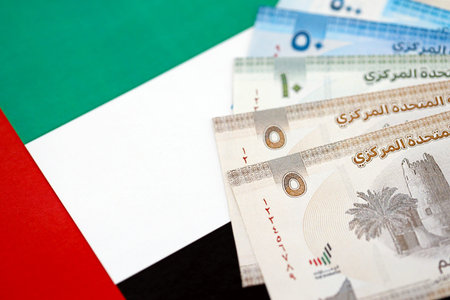 United Arab Emirates dirham currency money bills lies on flag close up. The concept of business and...
