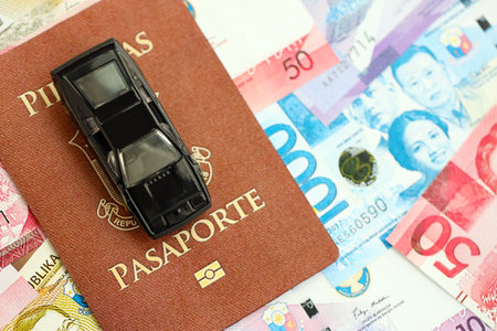 Philippines peso currency money bills and car with passport close up. The concept of car ownership