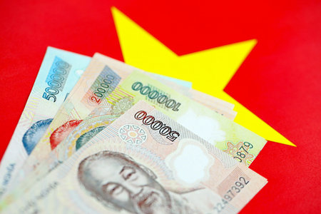 Vietnamese dong currency money bills lies on flag close up. The concept of business and investmentの写真素材