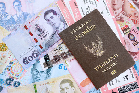 Thai baht currency money bills with tickets and passport close up. The concept of travel and...