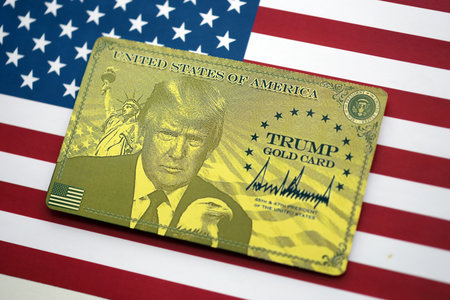 KYIV, UKRAINE - DECEMBER 13, 2025 Trump gold card souvenir on United States of America flag with...