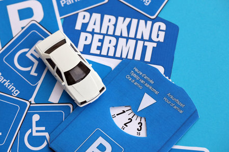 Parking permit paper notice tag and parking disc with toy car. Parking permit for people with...