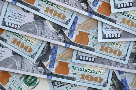 Many one hundred dollars money bills banknotes on smooth surface close up. Concept of business, rich...