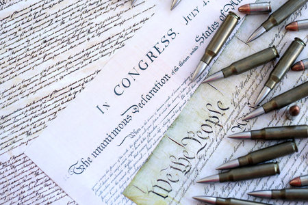 Gun control and second amendment in America concept. Bullets on american constitution with close up...