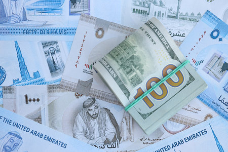 United Arab Emirates dirham currency money bills and bunch of us dollar banknotes close up. The concept of economics and currency exchangeの写真素材