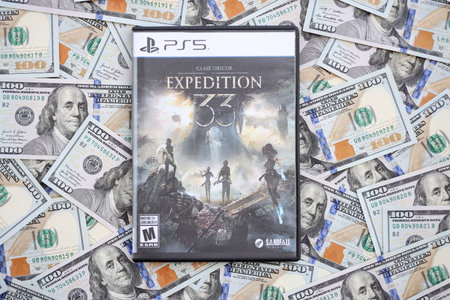 KYIV, UKRAINE - SEPTEMBER 8, 2025 Clair Obscur Expedition 33 videogame lies on big amount of hundred dollar bills close upのeditorial素材