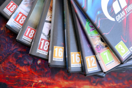 KYIV, UKRAINE - SEPTEMBER 8, 2025 PEGI game rating on a stack of PlayStation5 videogames close up. Pan European Game Informationのeditorial素材