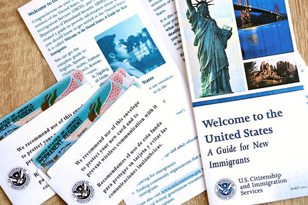 KYIV, UKRAINE - AUGUST 31, 2025 Permanent resident green card in envelope and guide for new...