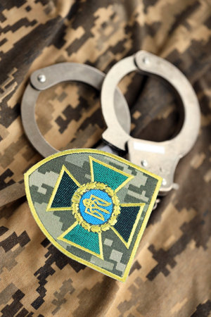 KYIV, UKRAINE - OCTOBER 7, 2025 State Border Guard Service of Ukraine patch and handcuffs on camo...