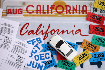 KYIV, UKRAINE - OCTOBER 1, 2025 Many California car registration tag stickers on license plate close...