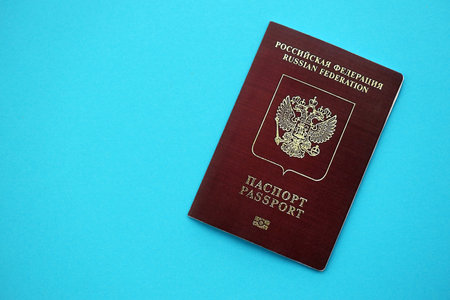 Russian Federation red passport on light blue table background close up. Concept of travel and tourismの写真素材
