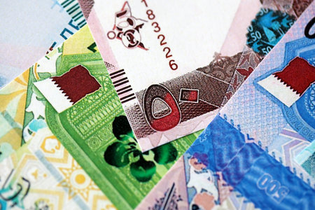 Qatari riyal money bills banknotes lies in big pile on table close up. Concept of finances and...