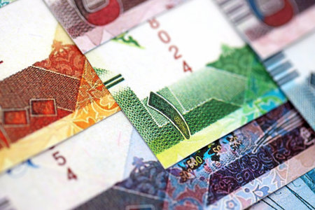 Qatari riyal money bills banknotes lies in big pile on table close up. Concept of finances and...