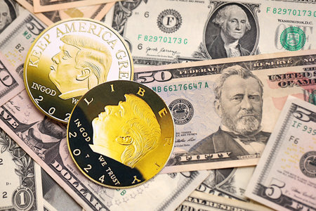 KYIV, UKRAINE - DECEMBER 13, 2025 Trump gold coin on big amount of US dollar money bills banknotes...