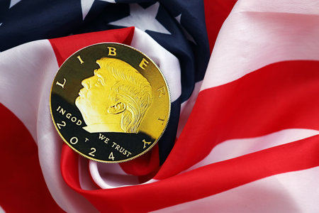 KYIV, UKRAINE - DECEMBER 13, 2025 Trump gold coin on United States of America folded waving flag...