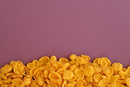 Background of breakfast cereals in big amount on purple background close up, top view