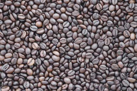 Coffee texture roasted beans from above soft light. Big amount of coffee beans