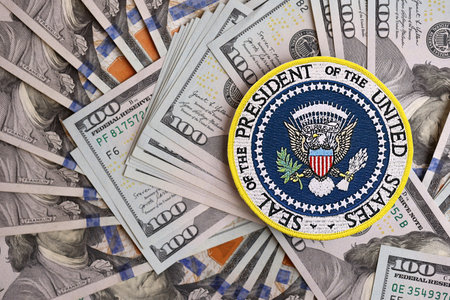 KYIV, UKRAINE - DECEMBER 13, 2025 Seal of the President of the United States sticker on big amount of US hundred dollar bills banknotesのeditorial素材