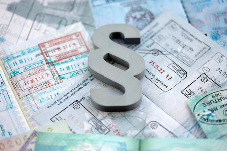 Paragraph symbol on passport pages full of colorful stamps after travel and tourism. Border control...