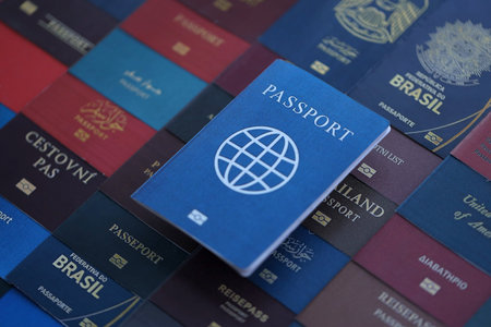 Fictional passport book travel document on big amount of real passport covers of various different...
