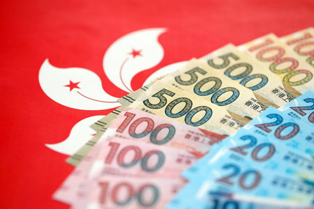 Big pile of Hong Kong dollars money bills banknotes on red flag. Lots of money of Chinese Hong Kong...