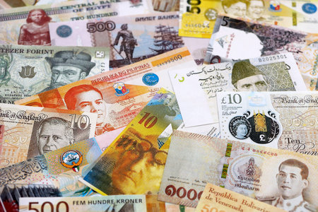 Various currencies money bills banknotes in yellow and orange color. Many cash bills from different...
