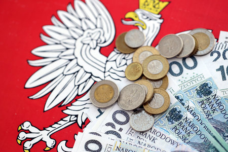 Banknotes of Polish zloty and grosz coins currency on polish flag. Poland PLN money close up....