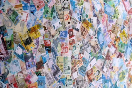 Different money banknotes from many currencies of the whole world. Big pile of money bills close up