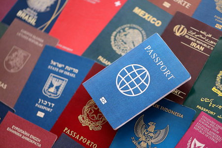 Fictional passport book travel document on big amount of real passport covers of various different...