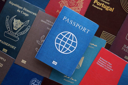 Fictional passport book travel document on big amount of real passport covers of various different...